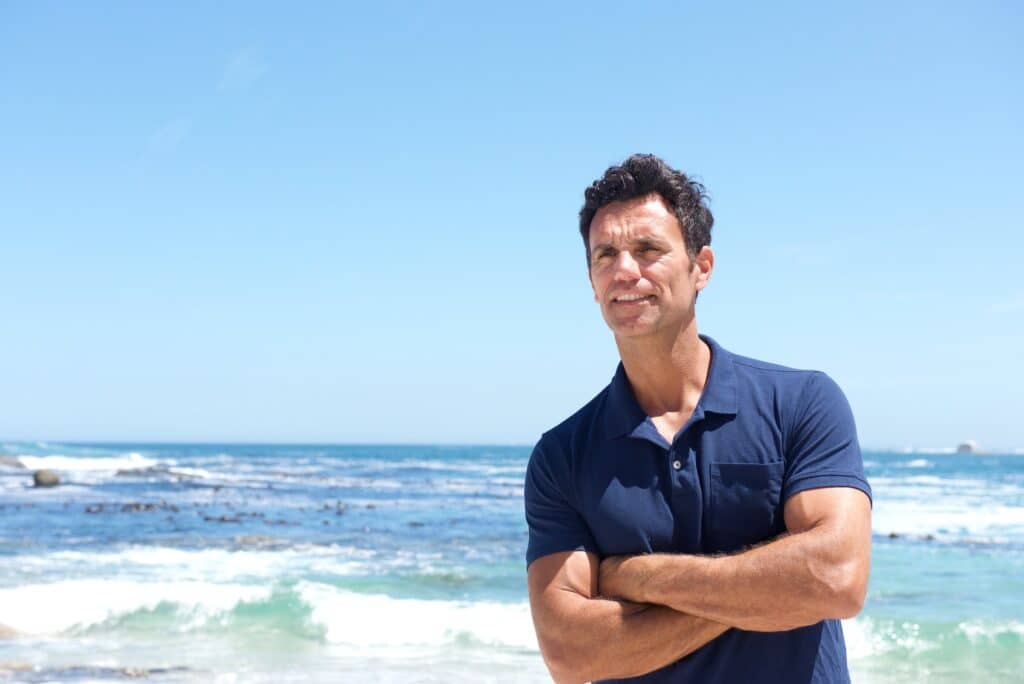 Rugged middle aged man standing at the beach